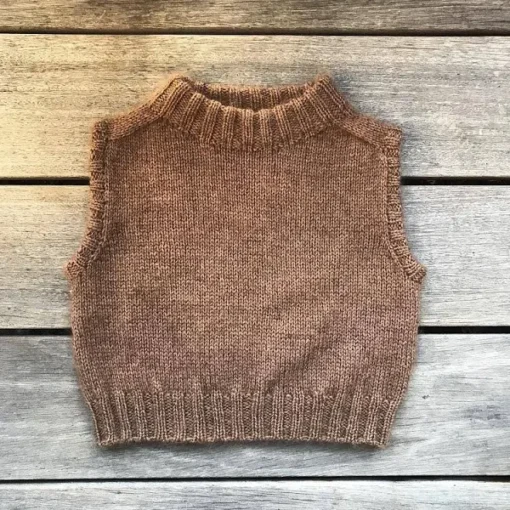 Olives vest er en enkel og klassisk basisvest til børn. Vesten strikkes oppefra og ned i glatstrik. Halsudskæringen formes med vendestrik, amtidig tages ud til skuldre. Vesten har ombukkede ribkanter i hals og ærmer. Kroppen afsluttes ligeledes i en ribkant. Størrelser: 1 (2) 4 (6) 8 (10) 12 år Længde: ca. 31 (33) 35 (39) 42 (45) 48 cm Bredde: ca. 30 (32) 34 (36) 38 (39) cm Pinde: Rundpind 3,5 mm og 4,5 mm, 80 cm Strikkefasthed: 20 m x 30 rækker = 10 x 10 cm i glatstrik på pind 4,5 mm Garn: 1 tråd Knitting for Olive Merino (250 m på 50 g) og 1 tråd Soft Silk Mohair (225 m på 25) g Modellen på billedet er strikket i Merino og Soft Silk Mohair – Mørk Cognac Garnforbrug: Merino: 100 (100) 100 (100) 100 (100) 150 g Soft Silk Mohair: 50 (50) 50 (50) 50 (50) 75 g