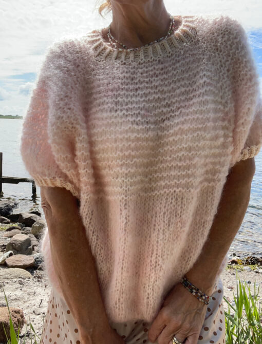 Smuk klassisk let oversize strik med korte ærmer. Kanterne er strikkede i kontrastfarve med sølv effekt. Strikkes oppefra og ned med raglenudtagninger. Størrelse: XS/S (M/L) XL/XXL Brystmål: ca. 105 cm (116 cm) 127 cm. Længde målt fra skulder og ned: ca. 49 cm (51 cm) 53 cm, eller ønsket længde. Ærmelængde målt fra ærmegab. ca. 8 cm (9 cm) 10 cm, eller ønsket længde. Strikkefasthed: 11 m = 10 cm på pind 9 Garn: Chunky mohair 200 m / 100 g. Merino 366 m /100 g. Der strikkes med en tråd mohair til blusen. Kanter med dobbelttråd. Forbrug: 2 fed/nøgler til Mohair og 1 fed merino til alle størrelser. Hvis der ønskes mere længde i str. XL/XXL da 3 fed/nøgler af mohair.